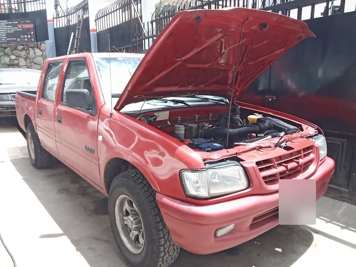 Camioneta roja con el capó abierto en revisión de motor